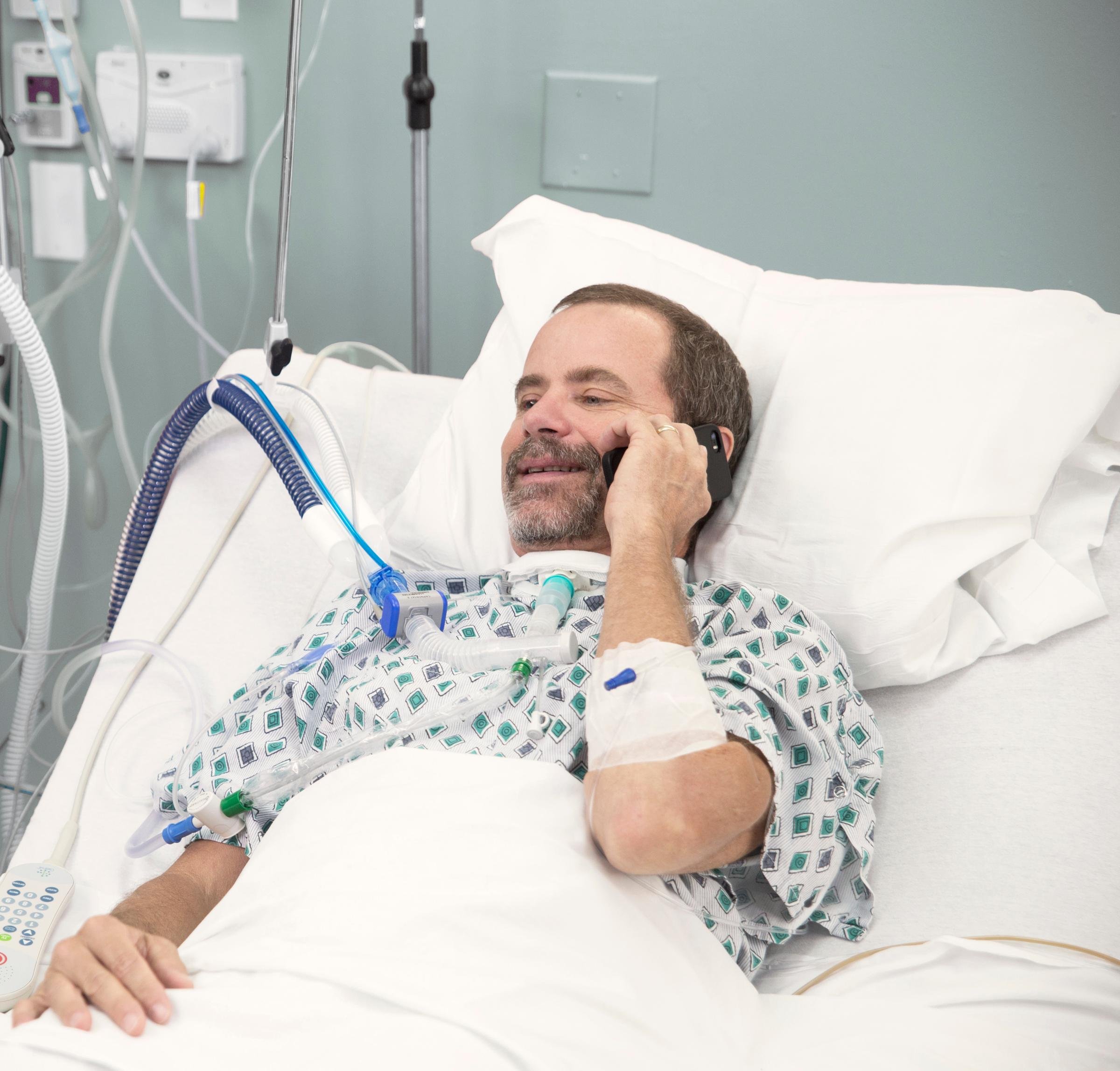 Patient mit Sprechventil-Option am Telefon.