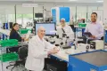 group of researches in a lab similing at the camera