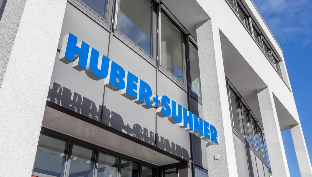 Bürogebäude-Eingang mit HUBER+SUHNER-Beschilderung Bürogebäude-Eingang mit HUBER+SUHNER-Beschilderung