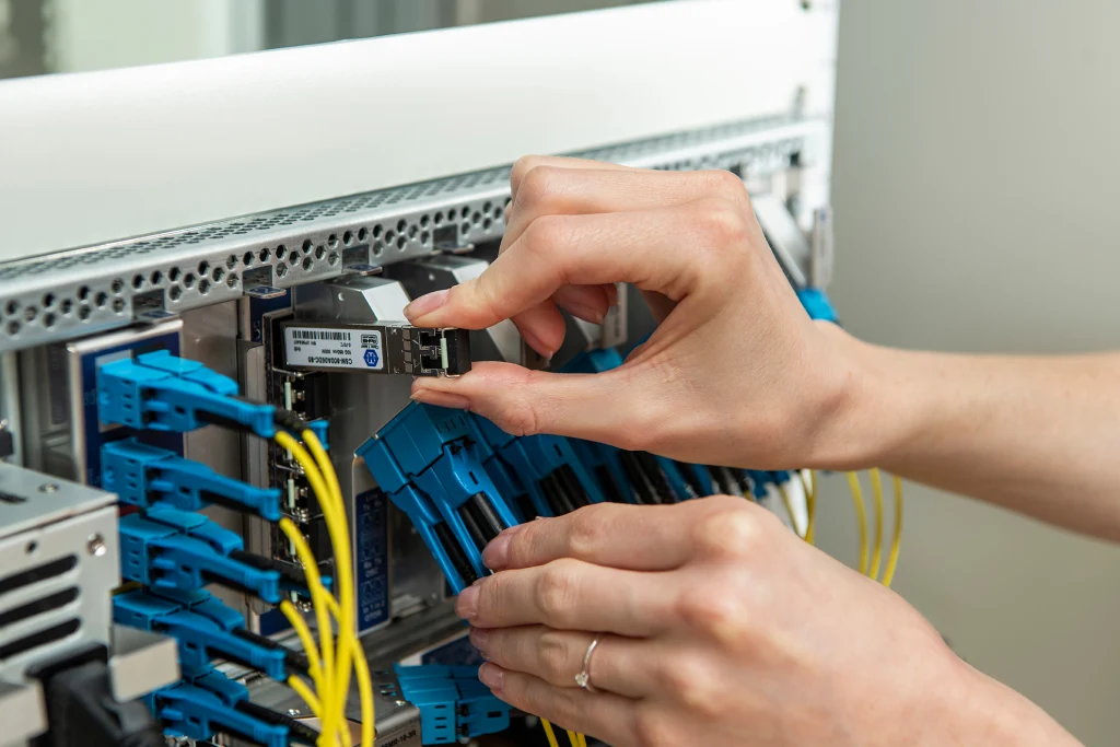 Close up of a hand plugging in a transceiver into a device