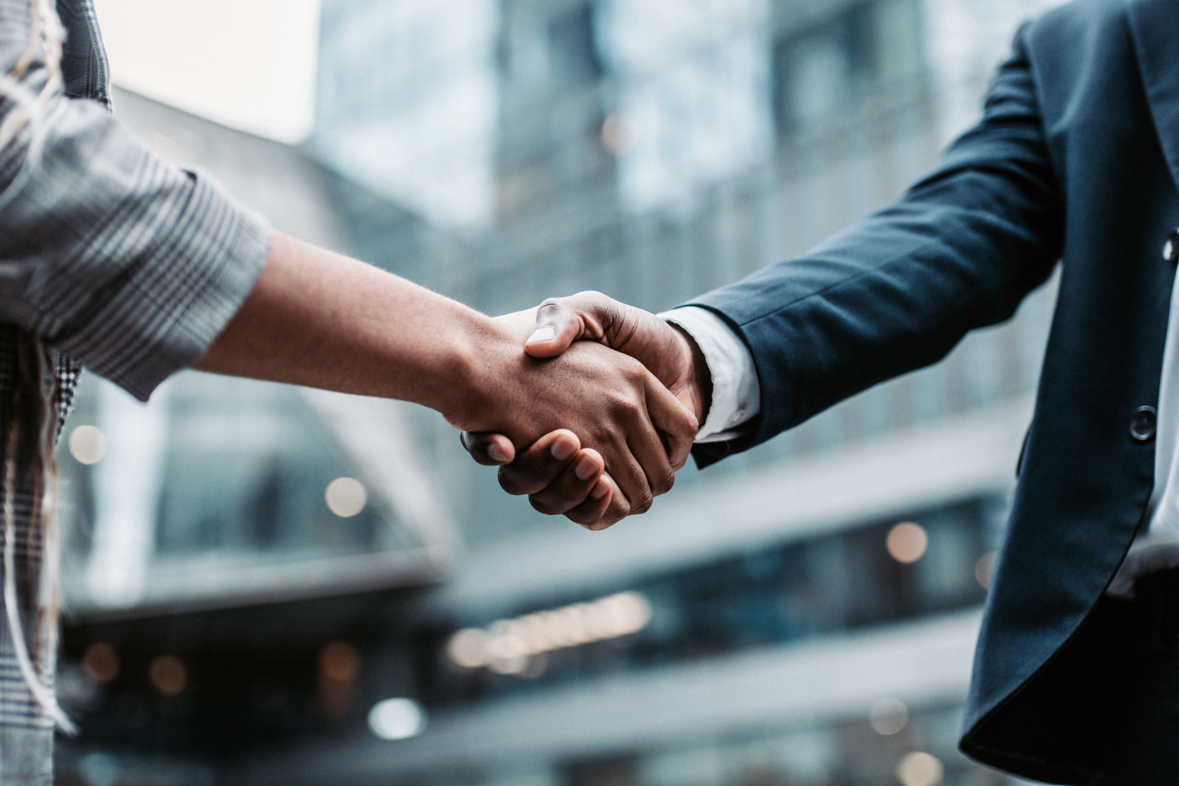 Two business people shake hands on the street