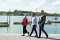 three persons walking next to a lake in Switzerland