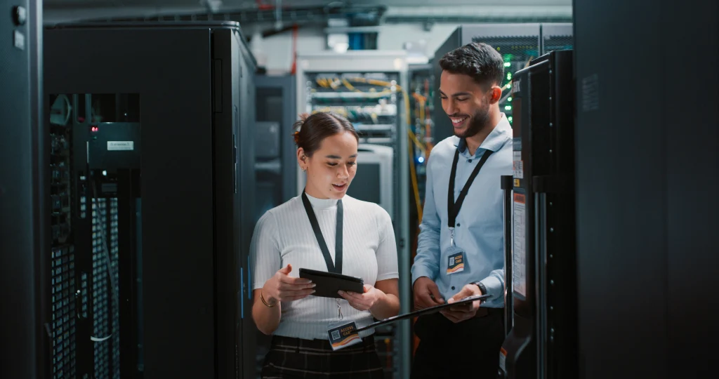 Data center operations with technicians using tablets to monitor network and server infrastructure. Data center operations with technicians using tablets to monitor network and server infrastructure.