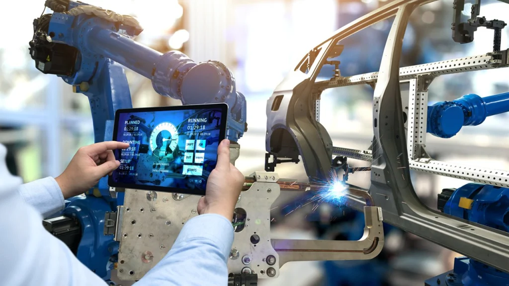 Ingenieur überwacht Produktionsanlagen in Echtzeit über ein Tablet. Im Hintergrund ein automatisierter Roboterarm in einer Smart Factory im Kontext von Industrie 4.0, IoT und digitalen Fertigungsprozessen. Ingenieur überwacht Produktionsanlagen in Echtzeit über ein Tablet. Im Hintergrund ein automatisierter Roboterarm in einer Smart Factory im Kontext von Industrie 4.0, IoT und digitalen Fertigungsprozessen.
