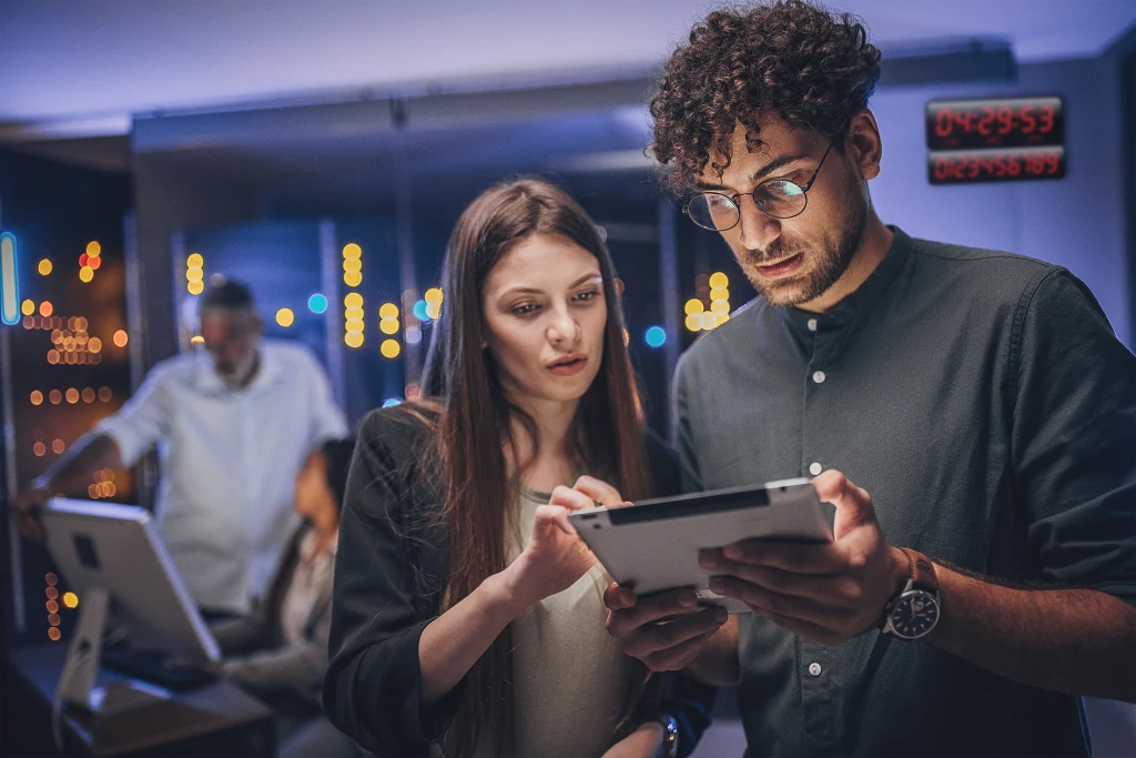 Zwei Kollegen analysieren Daten auf einem Tablet