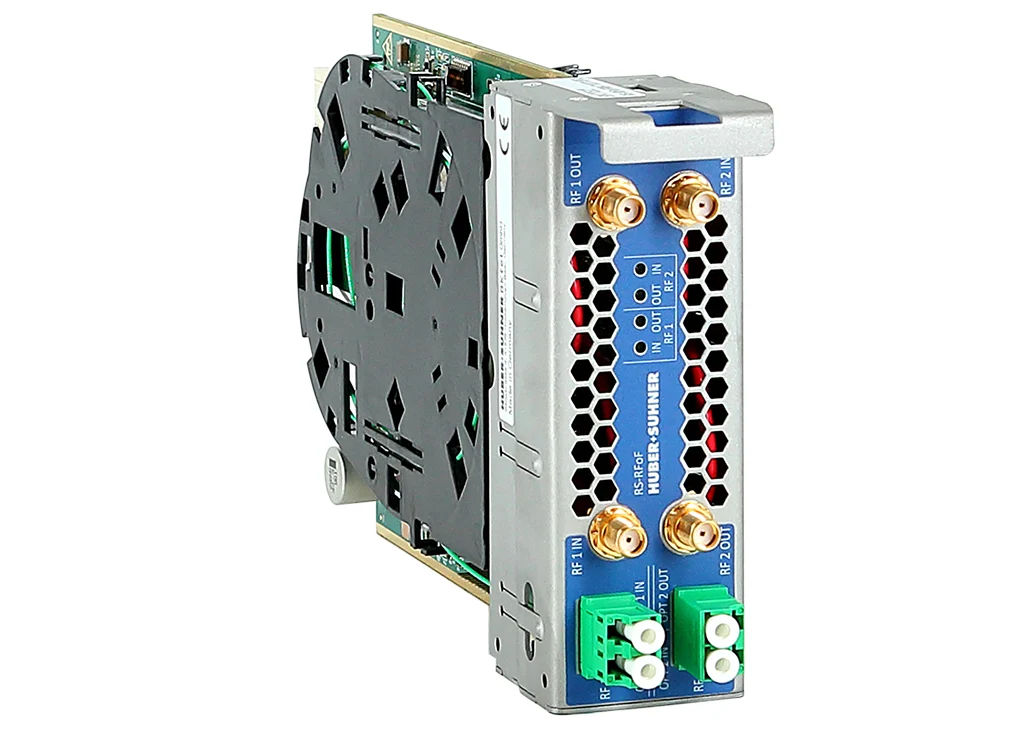 RF over fiber solution - Close-up of an industrial communication device featuring four RF connectors, two fibre optic ports and status indicators in a compact metal housing. RF over fiber solution - Close-up of an industrial communication device featuring four RF connectors, two fibre optic ports and status indicators in a compact metal housing.
