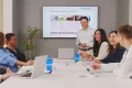 group of employees in a meeting room listening to a presentation