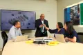 group of employees checking out a product in a meeting room