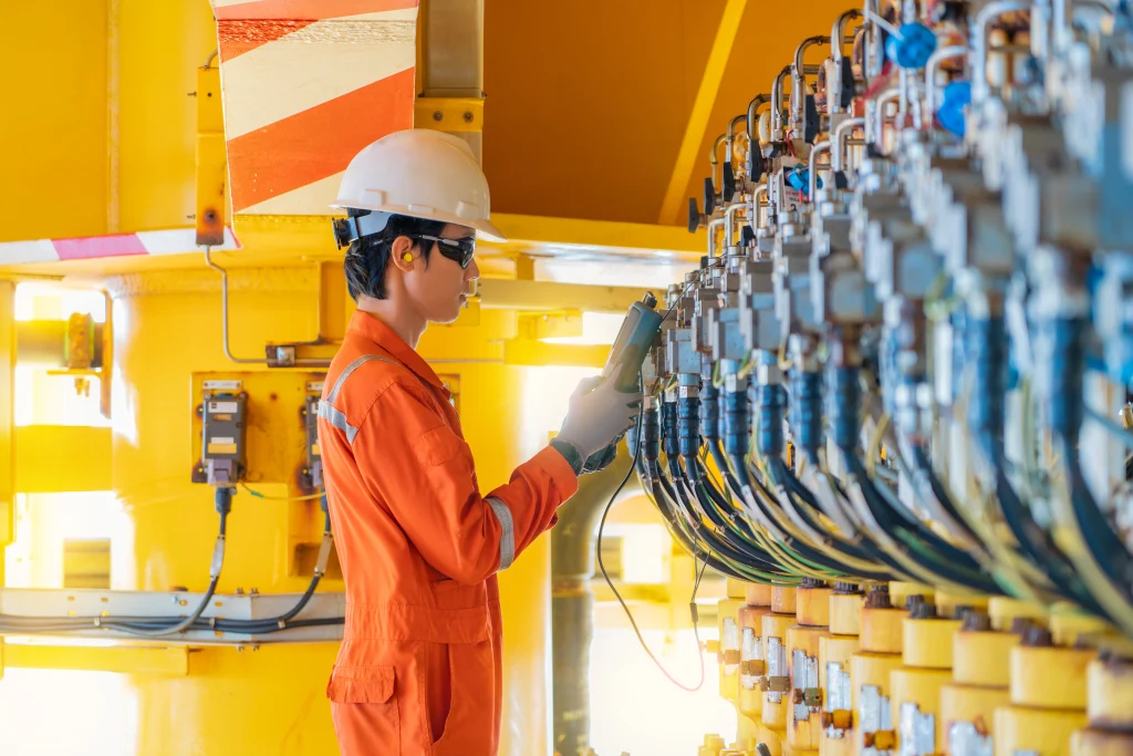 Elektro- und Messtechniker bei der Kalibrierung des Stellungsgebers eines automatisierten Drosselventils auf einer Offshore-Öl- und Gasförderplattform, Wartung und Service für die Industrie.
