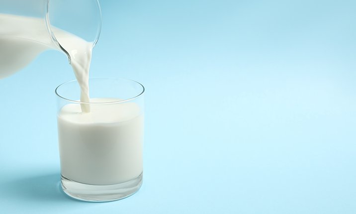 Does drinking milk make a cough worse Pouring Glass of Milk against a Blue Background