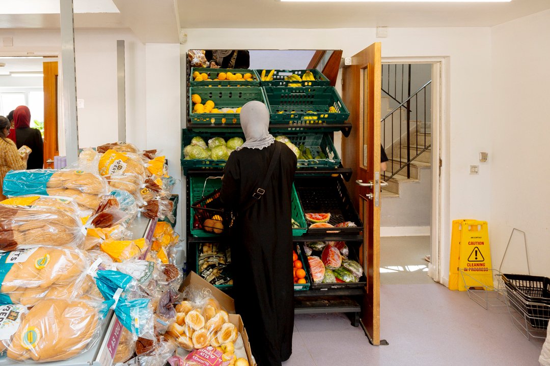 Back of head of woman choosing produce in community supermarket