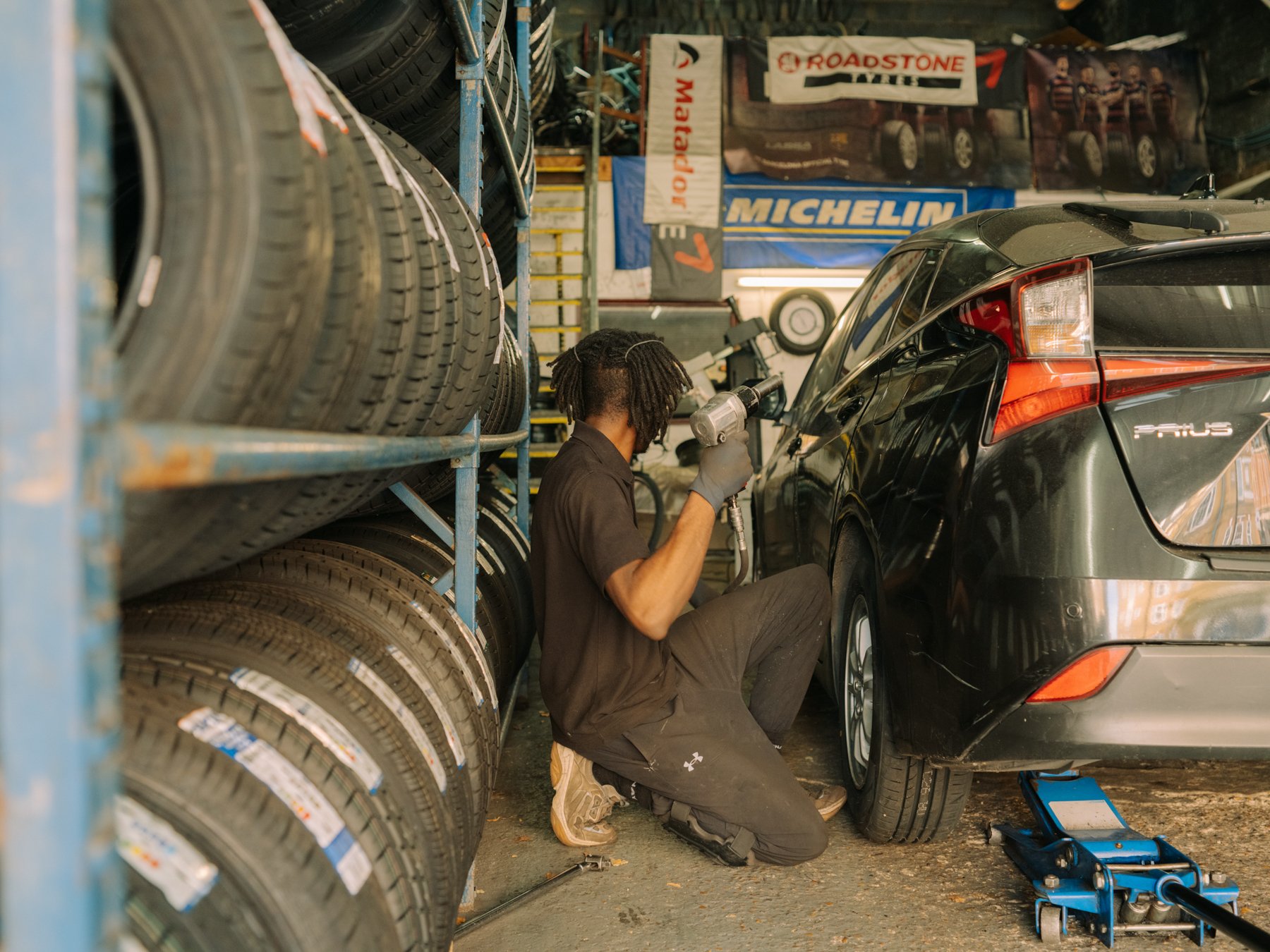 Mechanic knelt fixing car in garage