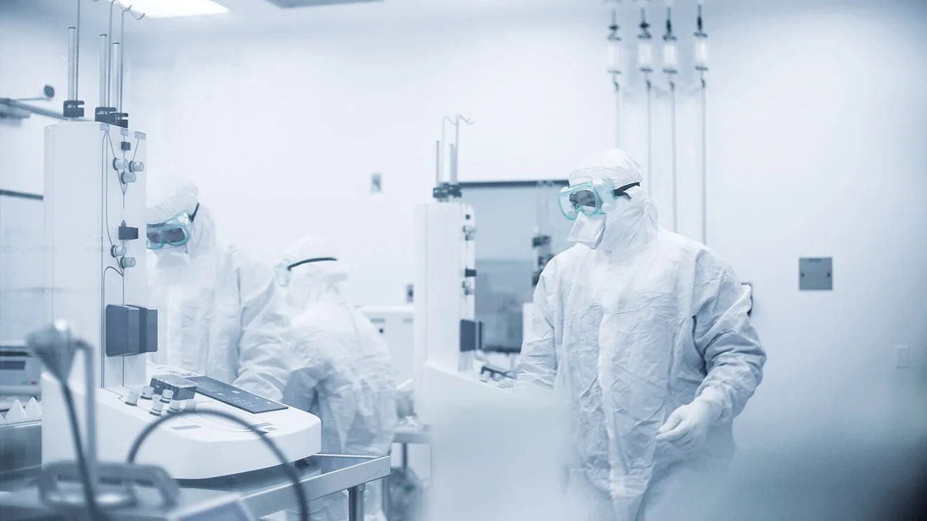 gowned technicians working in lab