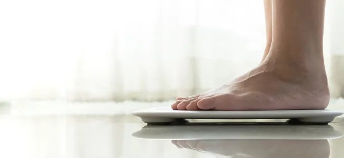 Close up of a person's feet standing on a scale