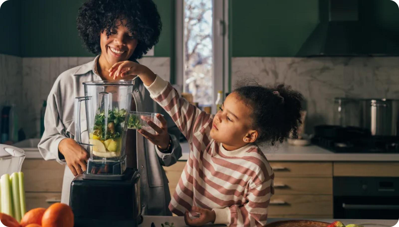 Adult and child making a nutritious smoothie together as part of building healthy lifestyle habits.