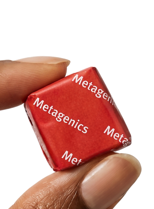 Hand holding a Metagenics StayStrong+ 4-in-1 Collagen Whole Body Chew against a gold background.