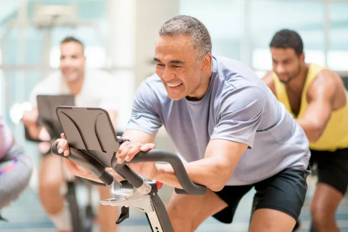 A group of smiling men in a spin class