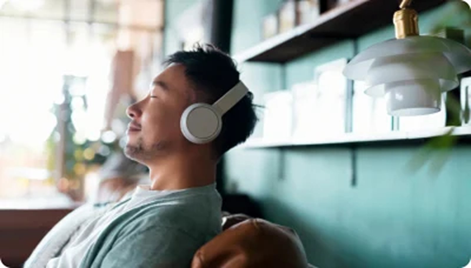 Person wearing headphones and relaxing indoors to support stress management and nervous system health.