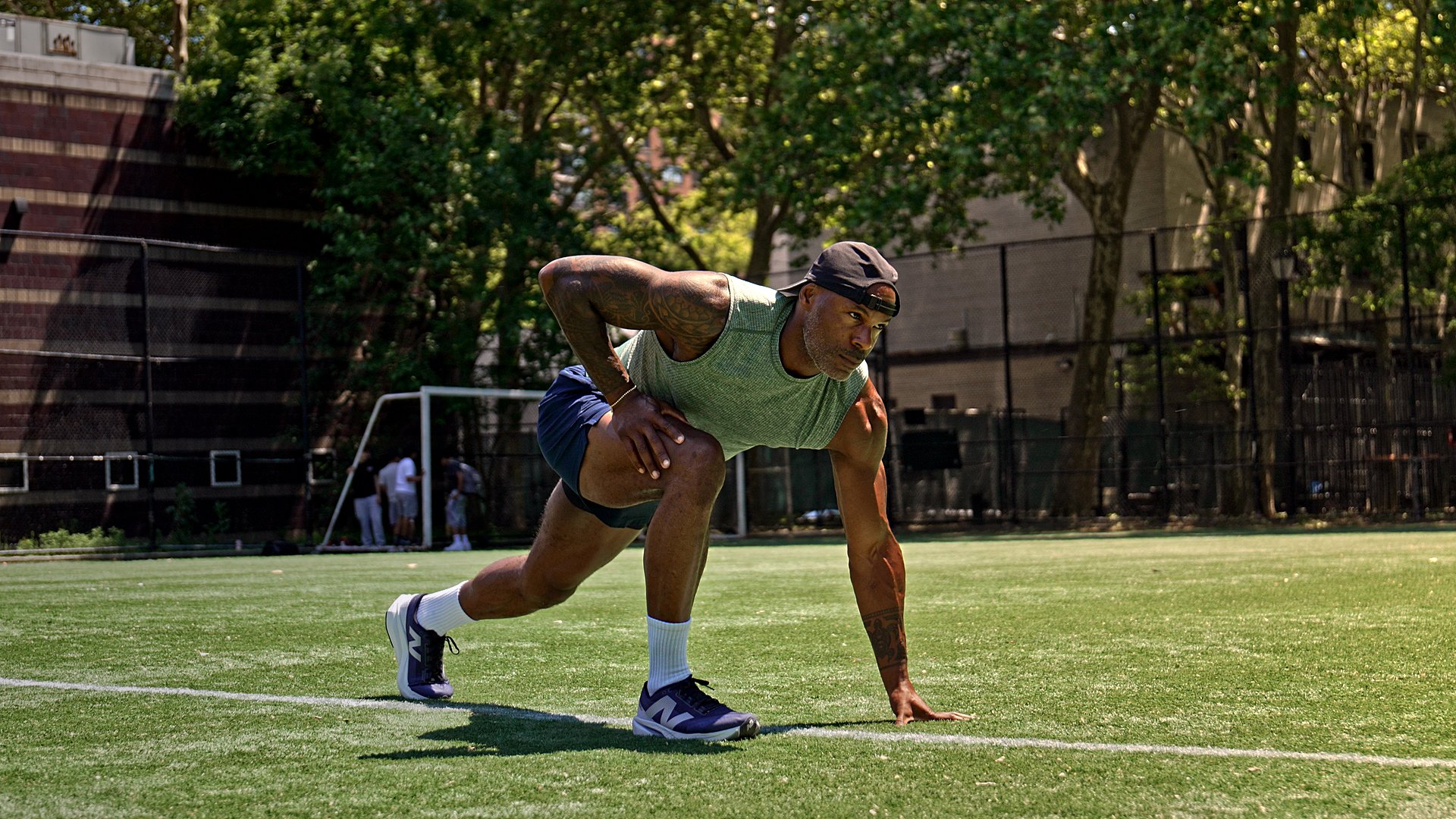 Adrian Williams stretching on a turf soccer field