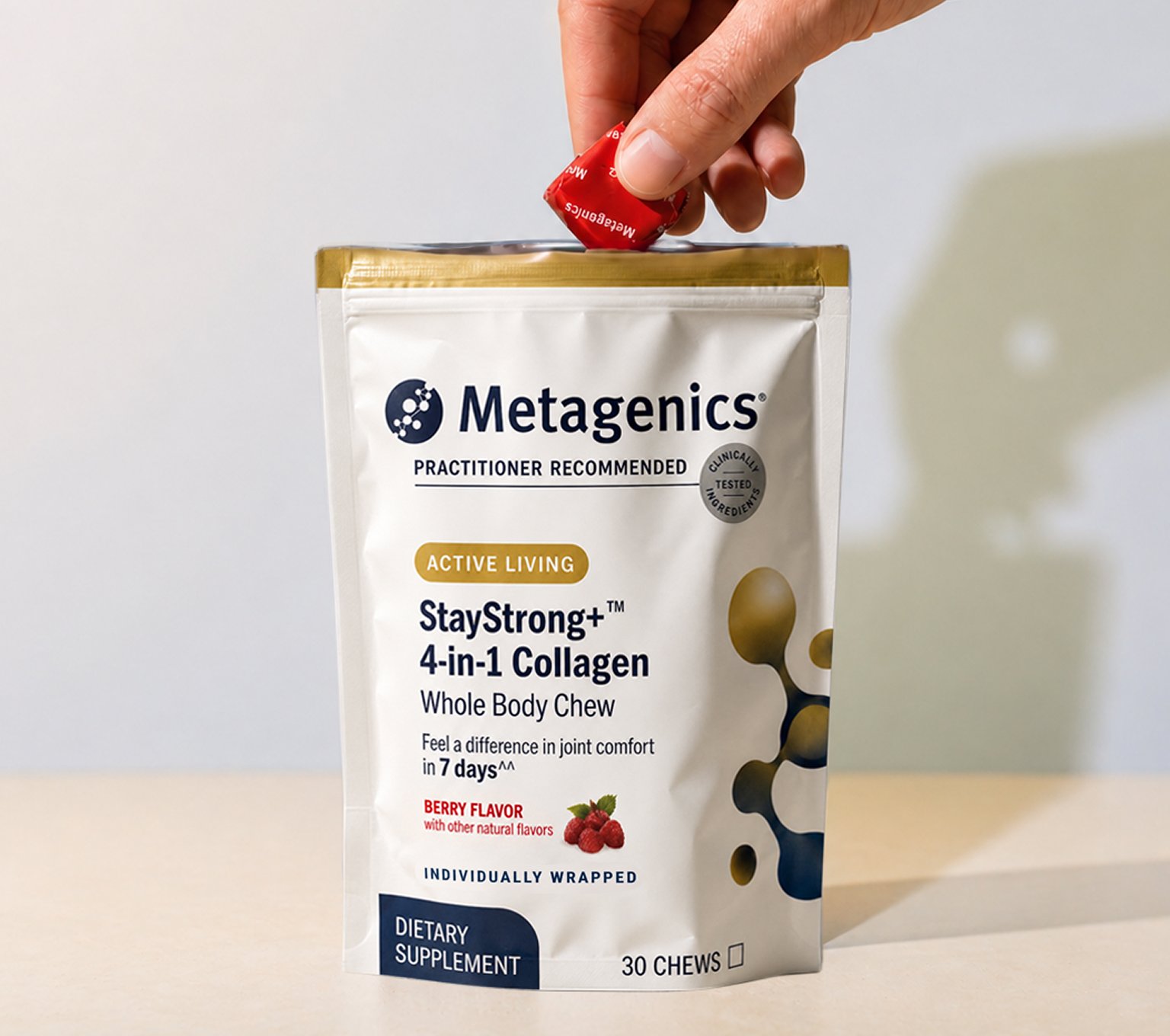 Hand taking a berry-flavored Metagenics® StayStrong+ 4-in-1 Collagen Whole Body Chew out of the resealable bag, featuring four specialized collagen ingredients for whole-body support.