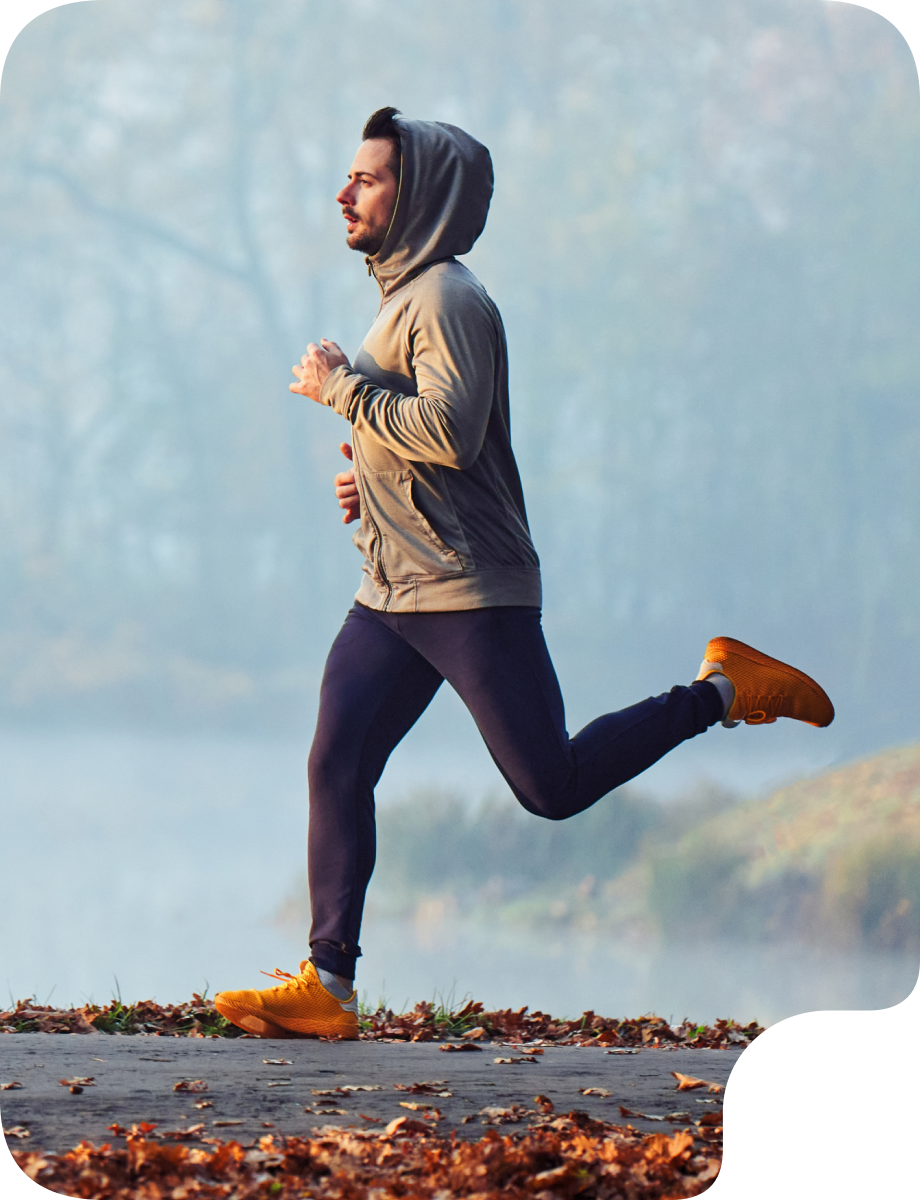 Person jogging outdoors on a trail during cool weather, representing energy, vitality, and mood support.