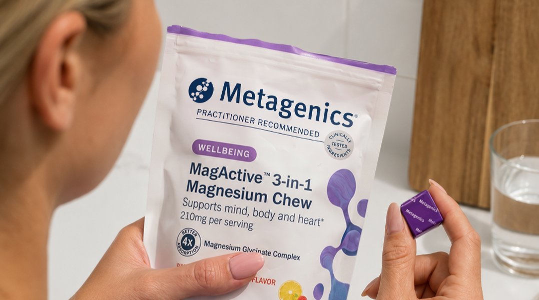 Person holding a bag of Metagenics MagActive® 3-in-1 Magnesium Chews and an individually wrapped chew, highlighting a return to healthy daily routines and wellness habits during seasonal transitions.