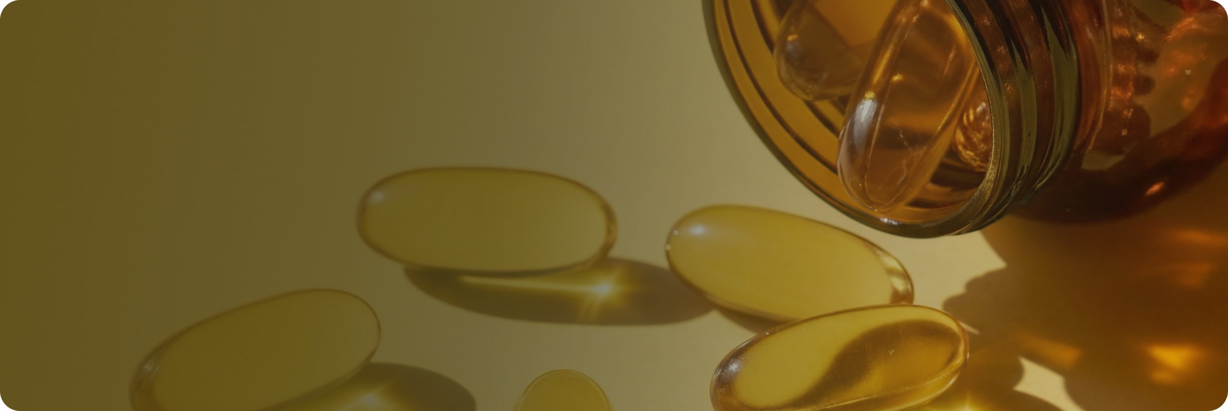 Golden softgel capsules beside an open supplement bottle, representing omega-3 and fish oil nutritional support.