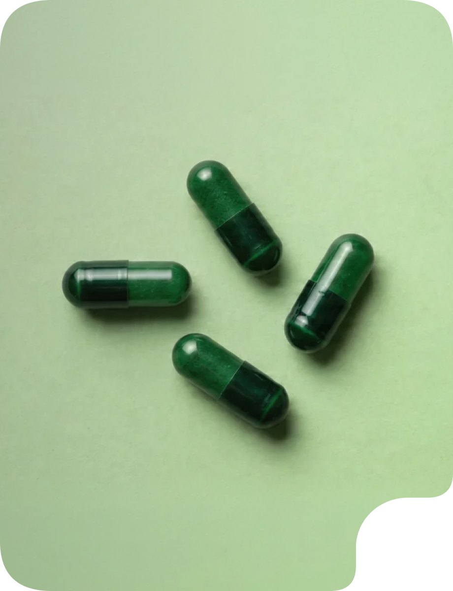 Green supplement capsules arranged on a light green background, representing digestive and gut health support.