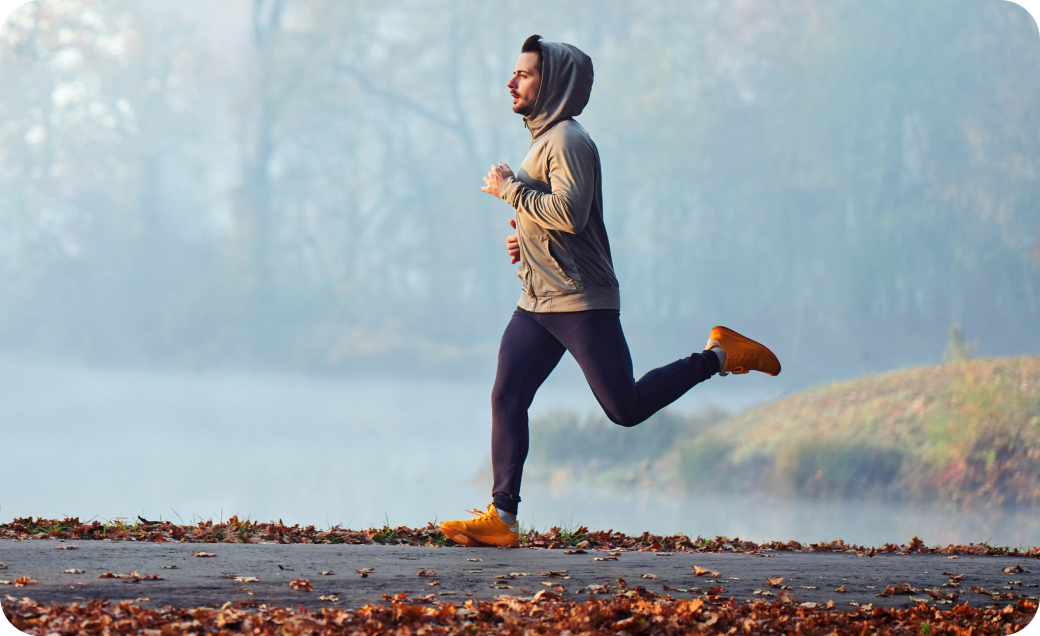 Person jogging outdoors on a trail during cool weather, representing energy, vitality, and mood support.