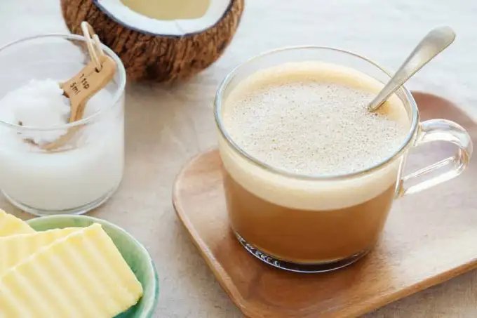 A selection of items to make a keto drink including coconut fat, butter and a mug of a hot drink.