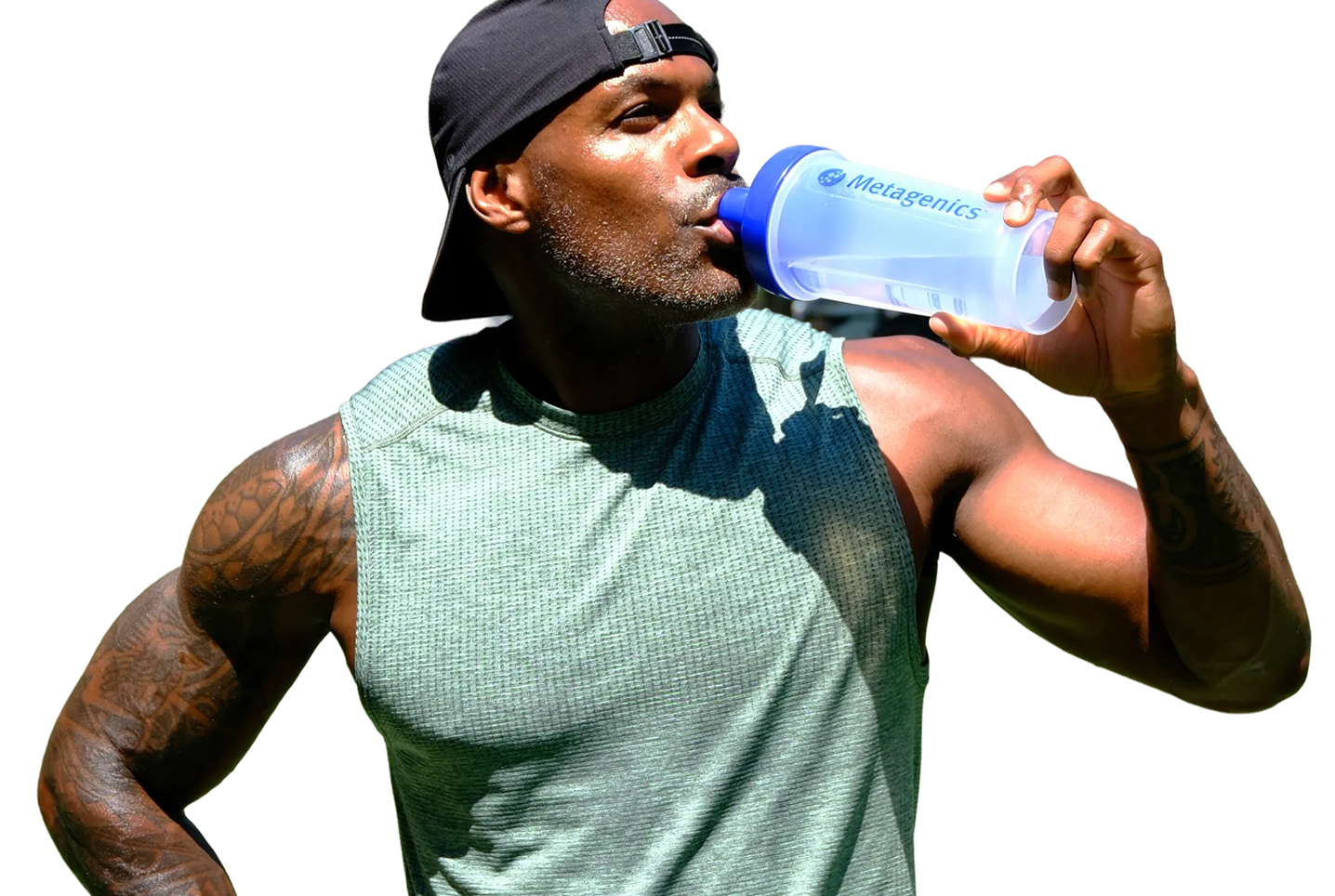 Adrian Williams drinks from a Metagenics shaker bottle while wearing a sleeveless green top and a backward black cap, highlighting the active lifestyle theme of the Metagenics StayStrong+ campaign.
