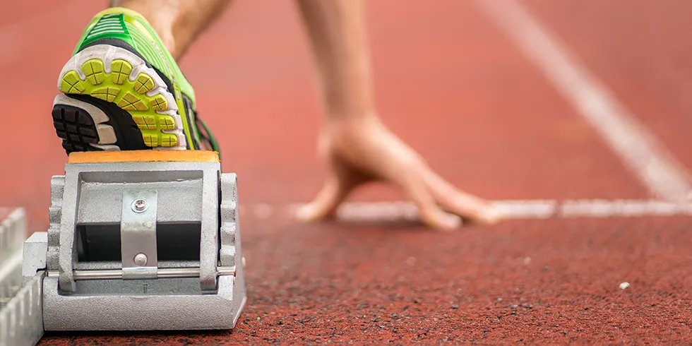 Closeup of an athlete's foot in the starter blocks for a race on track
