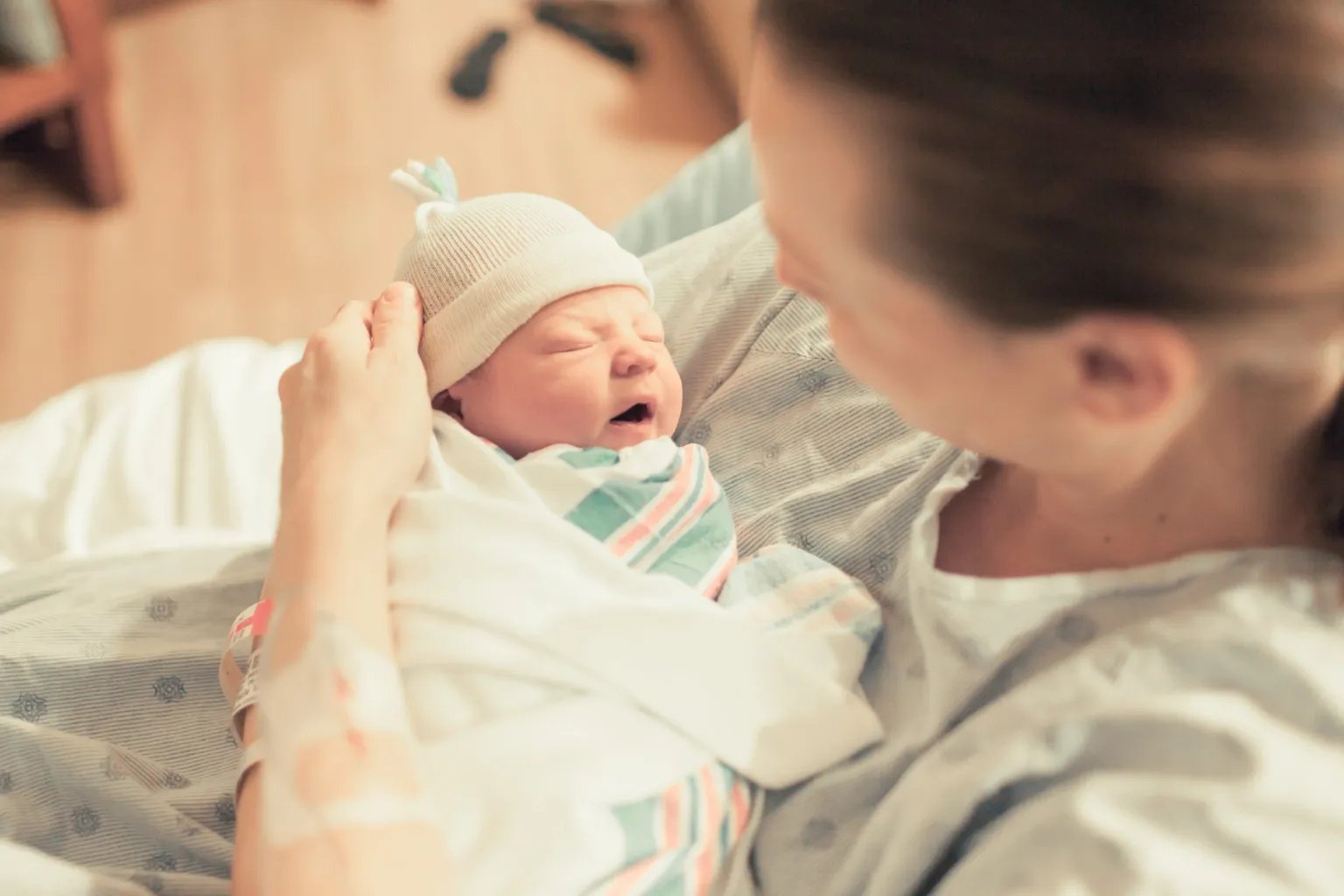 A mother holding her newborn baby in a hospital setting