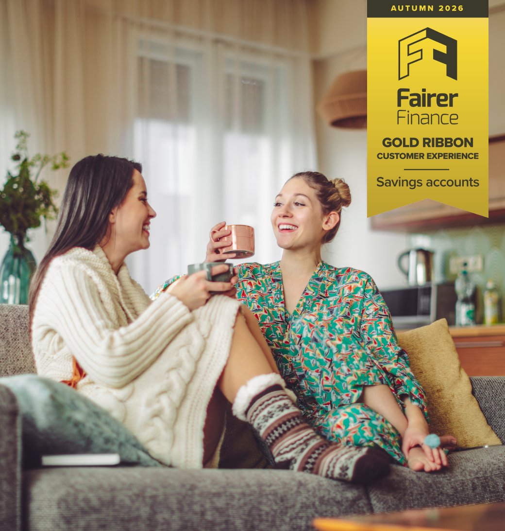 Two young women in loungewear drinking tea at home with spring 2026 Fairer Finance gold ribbon customer experience award for savings accounts overlayed on top.
