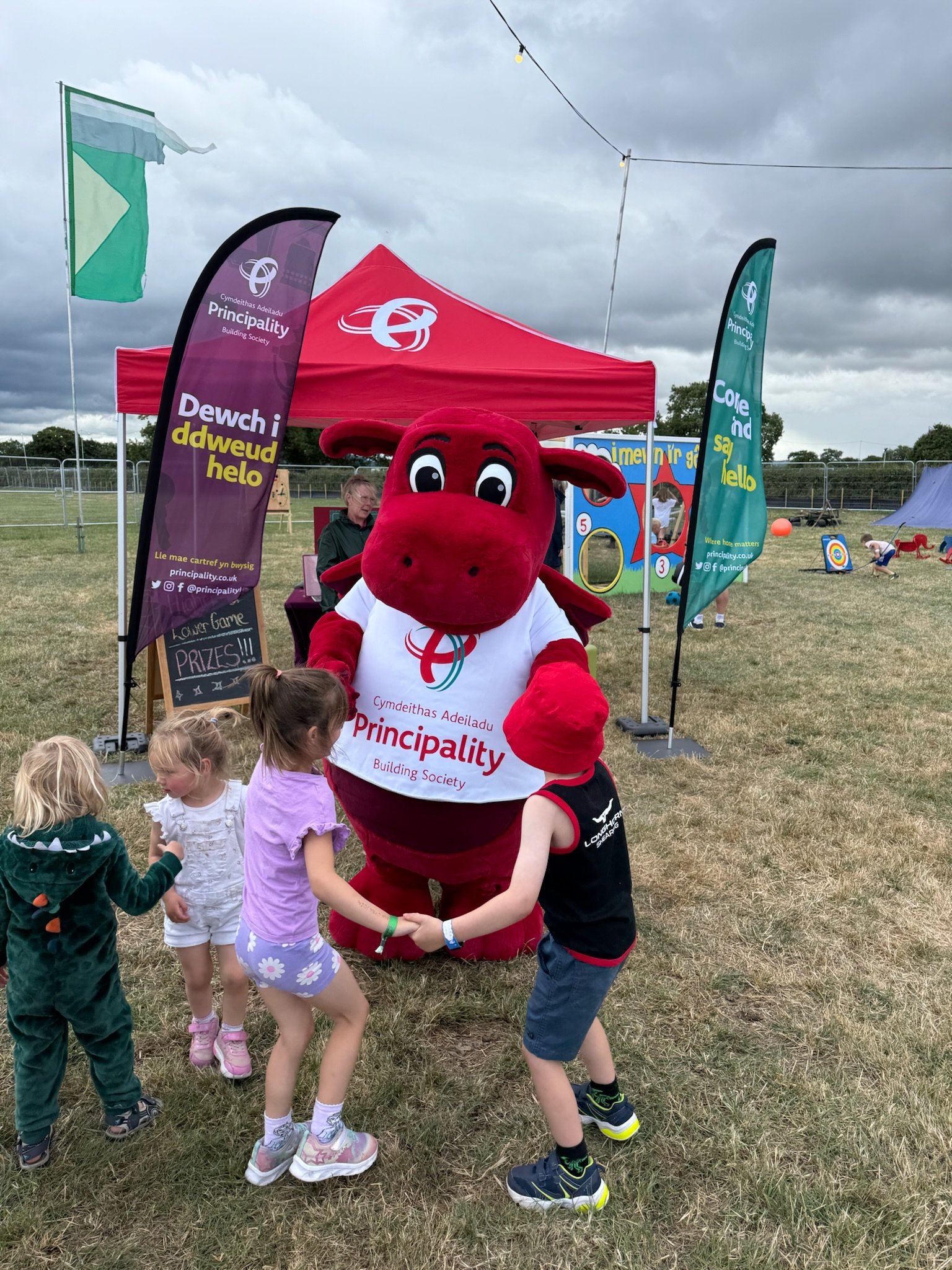 Principality Building Society mascot Dylan the Dragon interacting with children at the National Eisteddfod festival stand