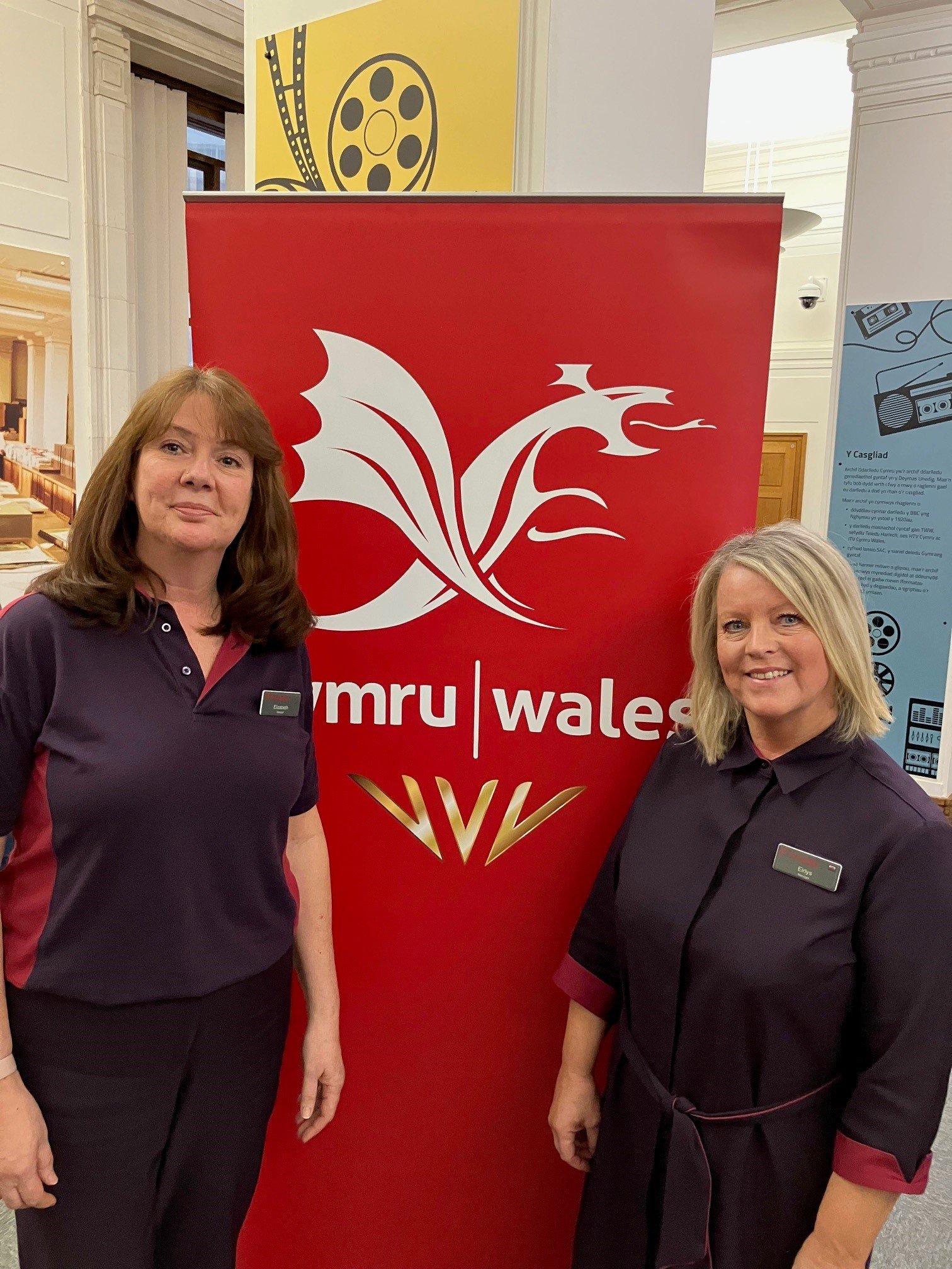 Two Principality customer consultants standing in front of the Team Wales logo at Commonwealth day 2025