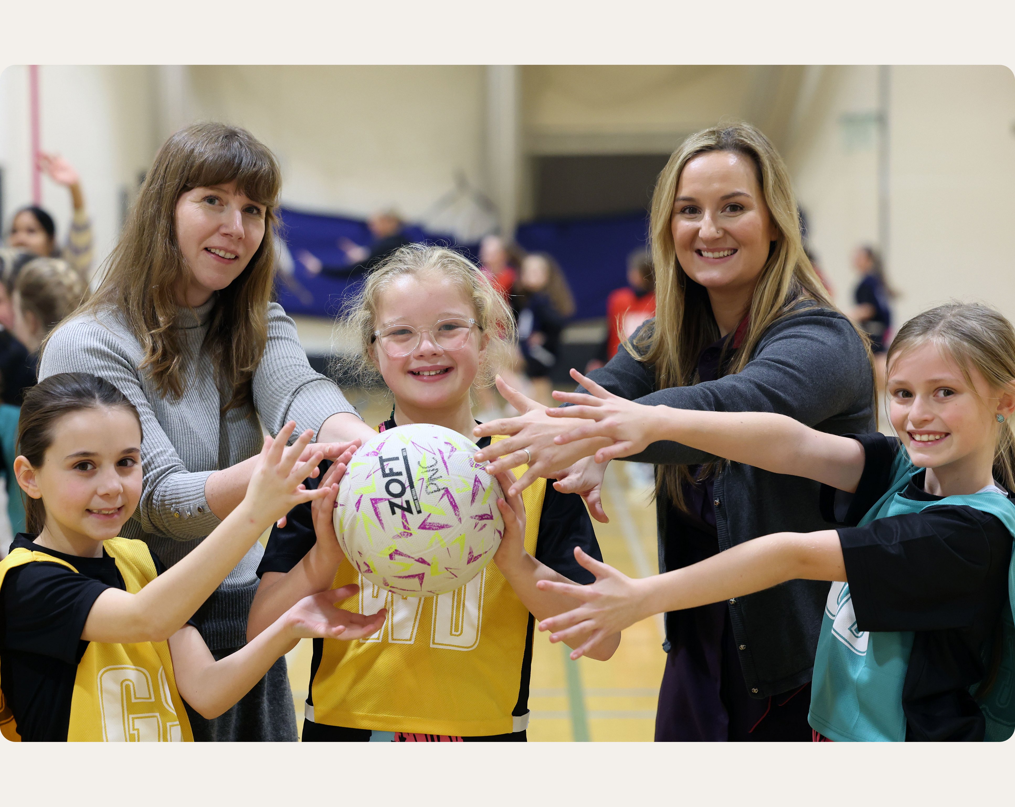 Principality employees posing with members of a netball team who've been awarded funding by the Future Generations Fund