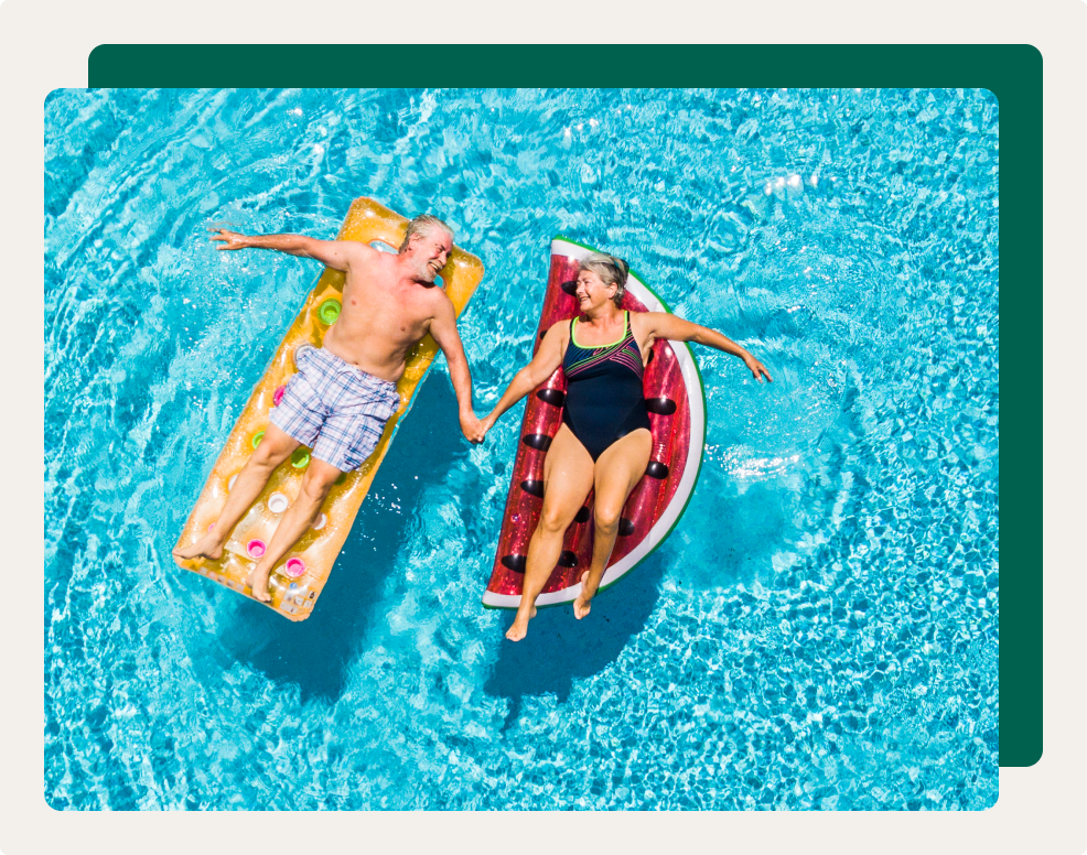 bove vertical view of people old senior couple taking hands with love and having fun on the blue clear swimming pool together 