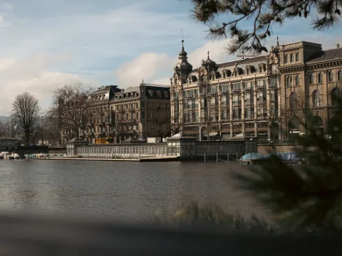 Le long de la rivière se trouve un long bâtiment plat avec un ponton flottant sur lequel on peut se promener. Des bateaux sont amarrés autour.