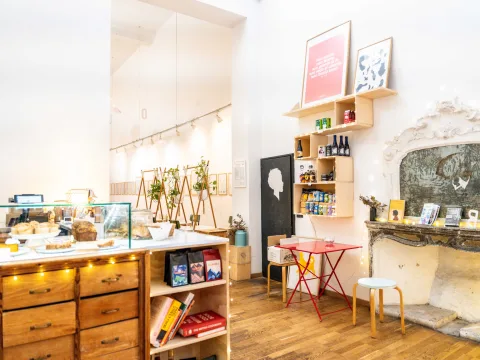 Bright cafe with vintage charm, marble counter, wooden shelves and fireplace