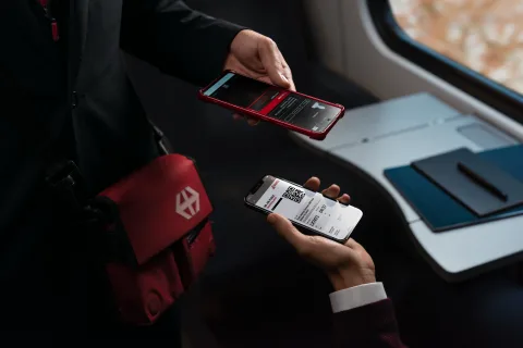 Ein Fahrgast zeigt bei einer Billettkontrolle sein SWISS Air Rail Ticket auf seinem Mobiltelefon.