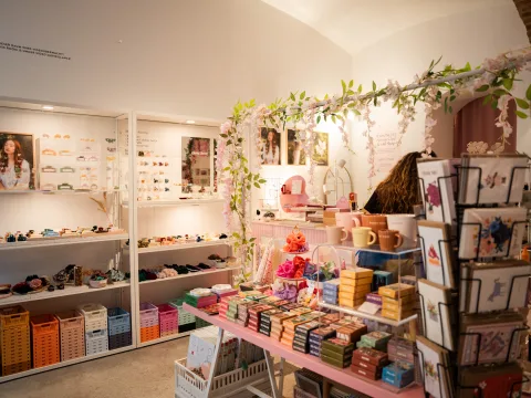 Interni dello store Maisonette a Vienna con accessori variopinti, biglietti di auguri, fermagli per capelli e decorazioni rosa.