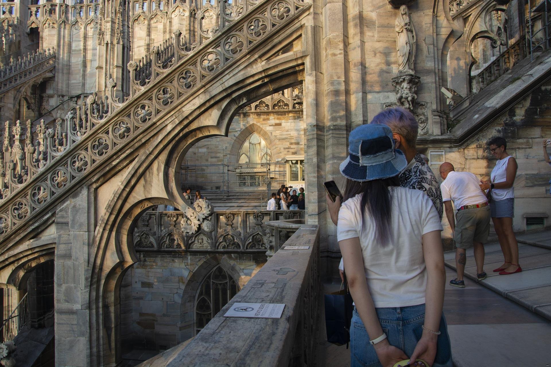 Persone in piedi sulla terrazza di un edificio.