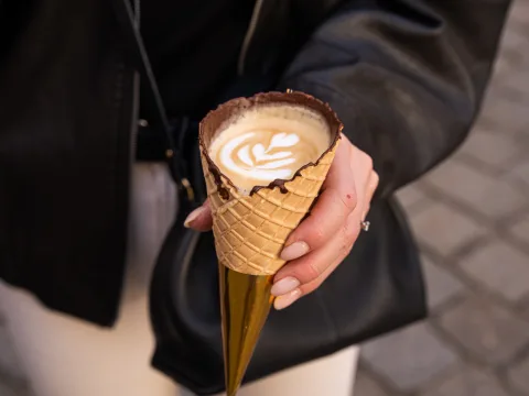 Cappuccino con latte art in una cialda gelato al cioccolato.