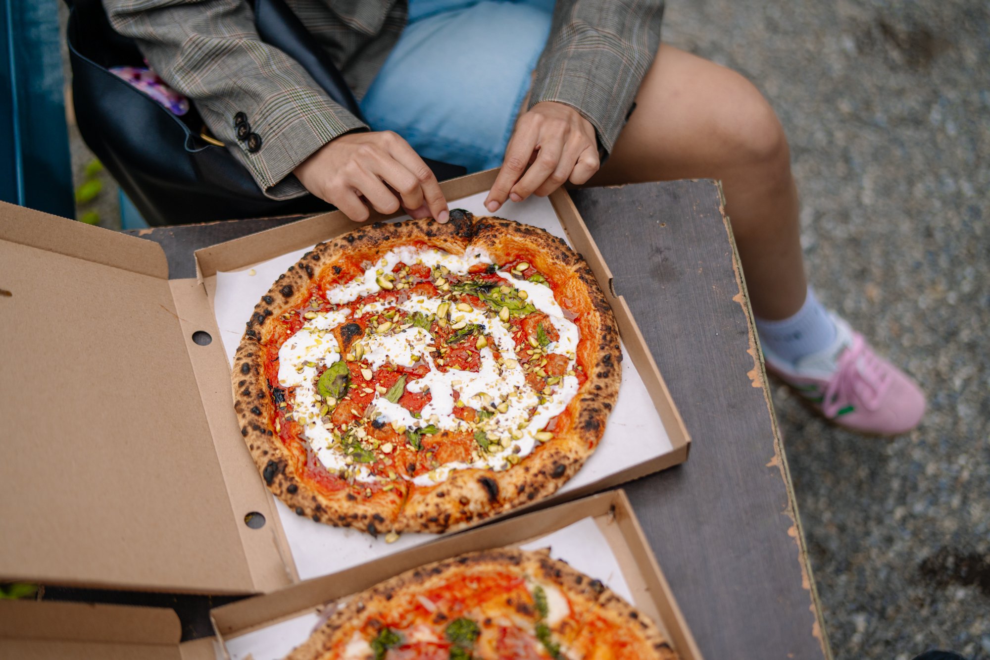 Geöffnete Pizzaschachtel mit einer Pizza drin.