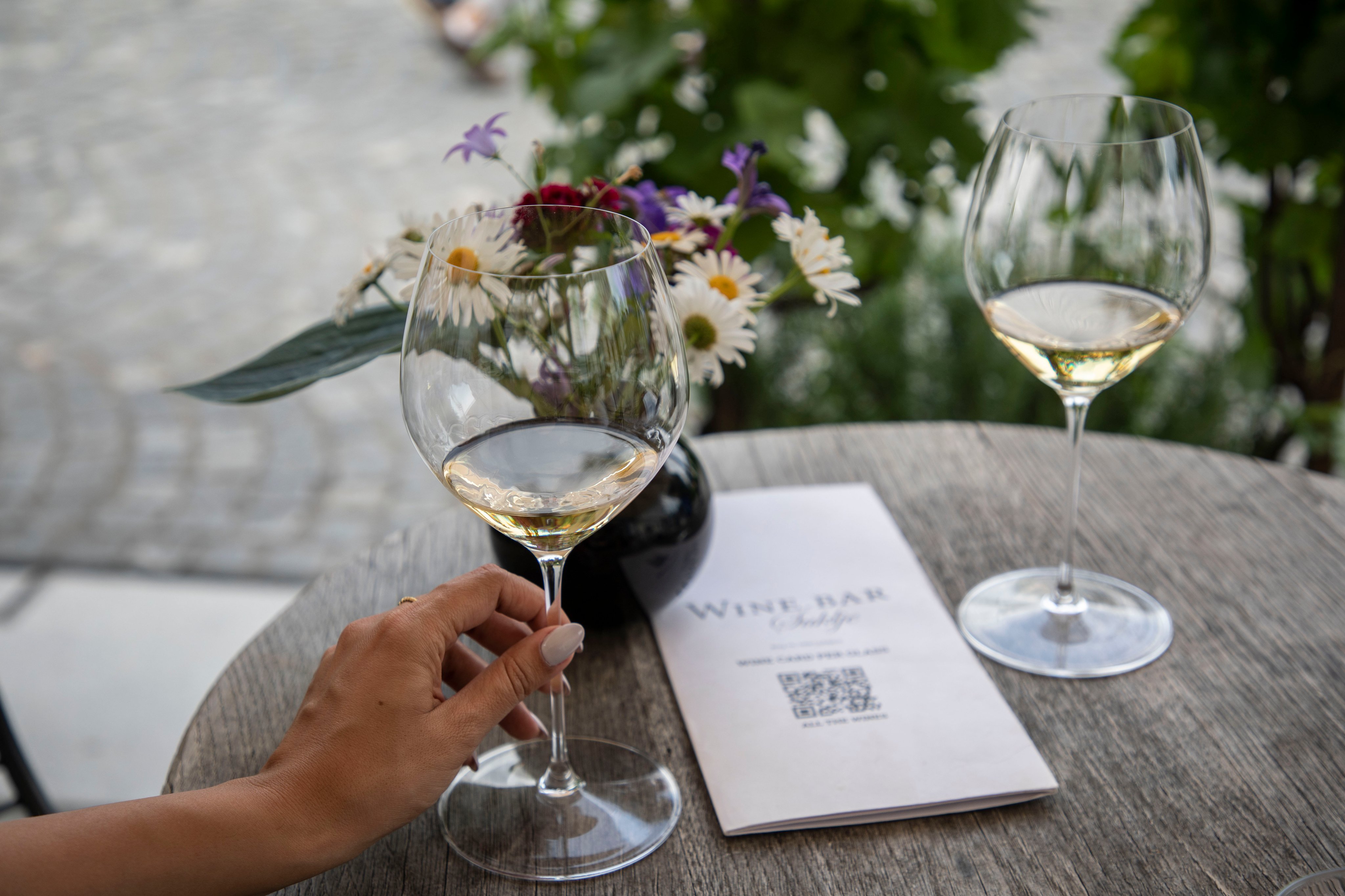 Eine Frau hält ihr Weinglas. 