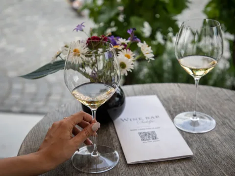 Eine Frau hält ihr Weinglas.