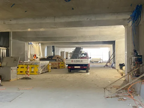 Il nuovo sottopasso ancora in costruzione, con le pareti in calcestruzzo, un veicolo di cantiere nel centro e sulla sinistra due operai al lavoro.