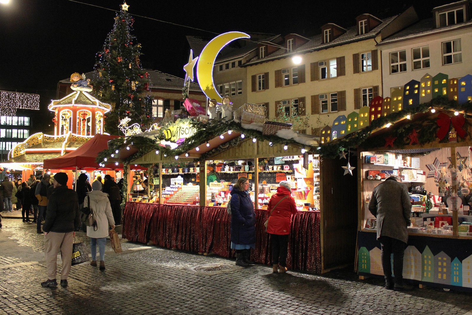 Les stands décorés pour Noël devant la vieille ville illuminée.