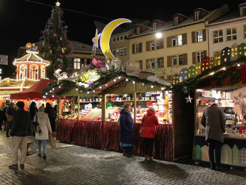 Les stands décorés pour Noël devant la vieille ville illuminée.